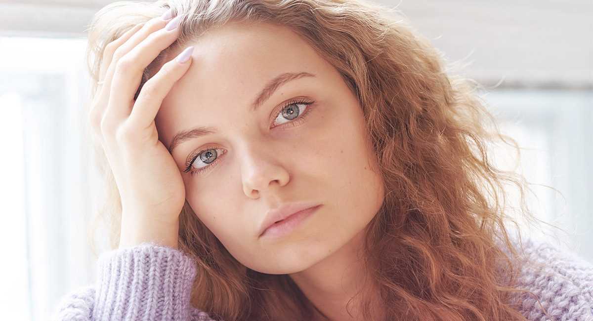 Depressed young woman near window at home, closeup   Image